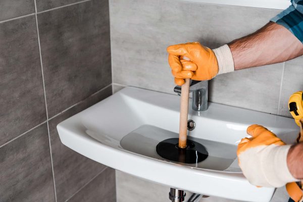 cropped-view-of-man-holding-plunger-in-sink-with-w-resize.jpg